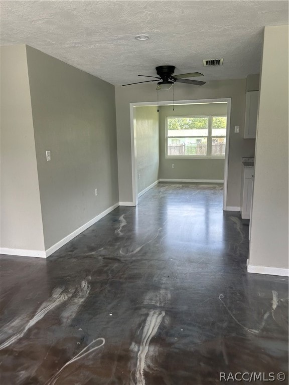 interior space with ceiling fan and a textured ceiling