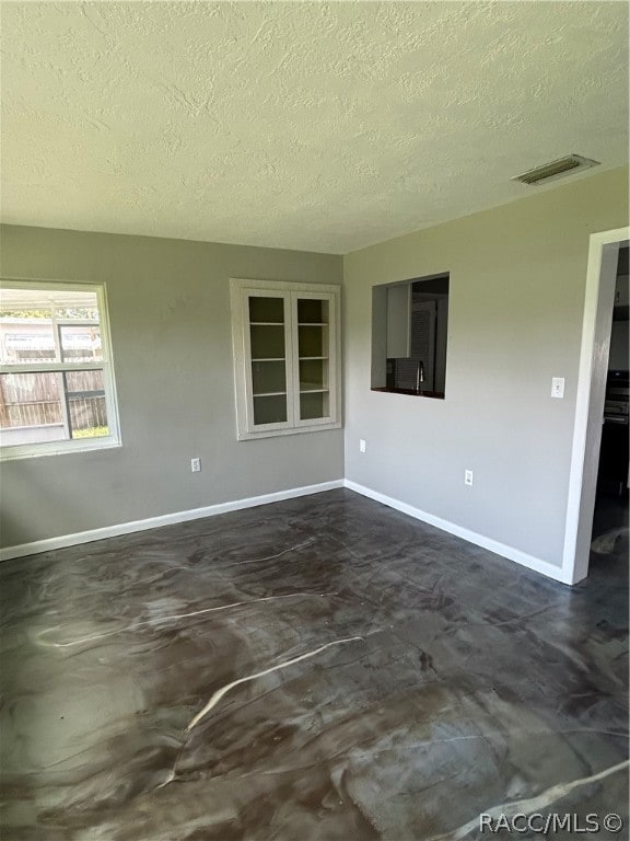 unfurnished room featuring a textured ceiling