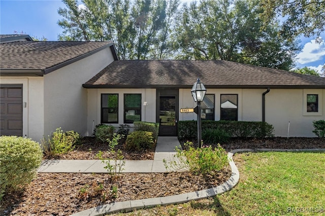 single story home featuring a garage and a front lawn