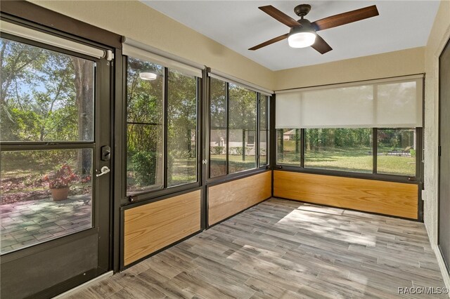 unfurnished sunroom with ceiling fan and a healthy amount of sunlight