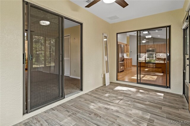 unfurnished sunroom featuring ceiling fan