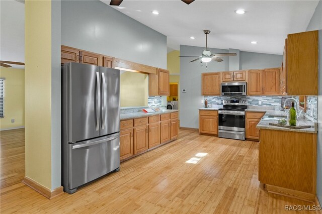 kitchen with sink, light hardwood / wood-style flooring, ceiling fan, stainless steel appliances, and decorative backsplash