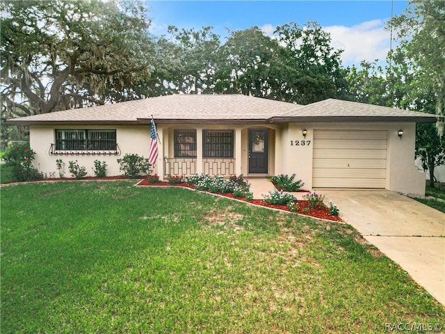 single story home featuring covered porch, a garage, and a front yard