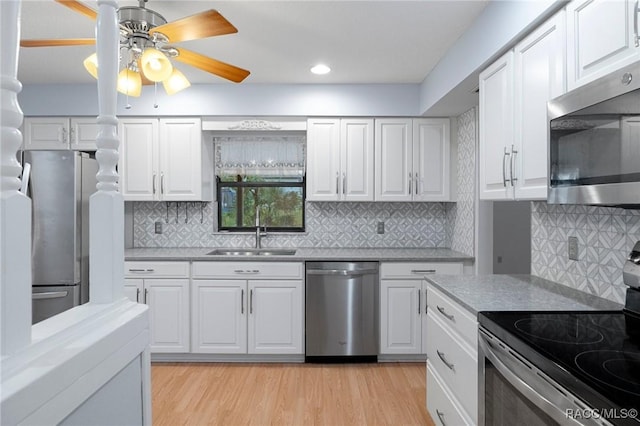 kitchen with sink, light hardwood / wood-style flooring, white cabinets, and appliances with stainless steel finishes