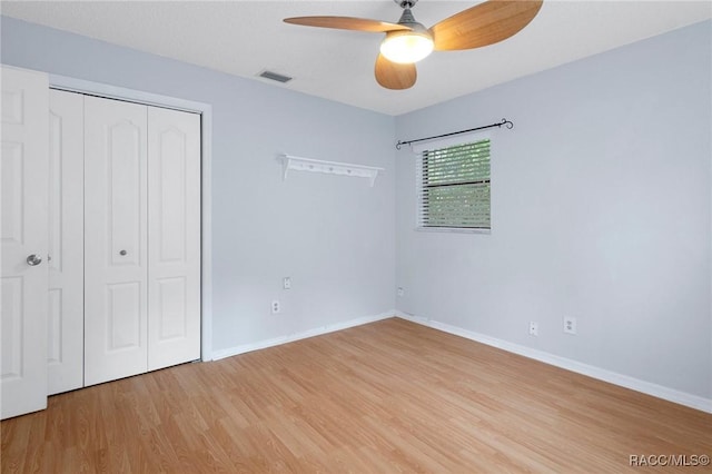 unfurnished bedroom featuring wood-type flooring, a closet, and ceiling fan