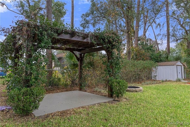 view of yard with a storage shed, a pergola, and a fire pit