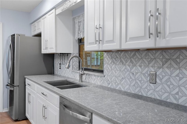 kitchen with white cabinetry, sink, appliances with stainless steel finishes, and tasteful backsplash