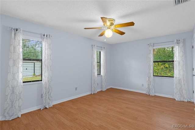 empty room featuring ceiling fan, light hardwood / wood-style floors, and a textured ceiling