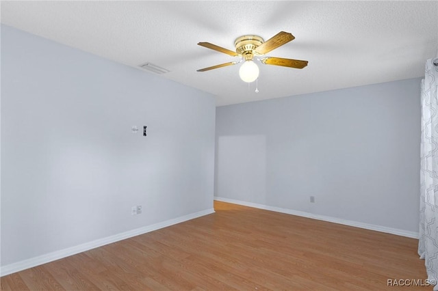 spare room with ceiling fan, light wood-type flooring, and a textured ceiling