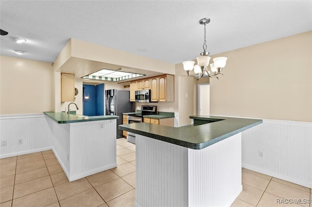 kitchen with stainless steel appliances, a chandelier, a textured ceiling, decorative light fixtures, and light brown cabinetry