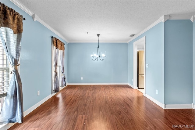 empty room featuring a wealth of natural light, hardwood / wood-style floors, a textured ceiling, and ornamental molding