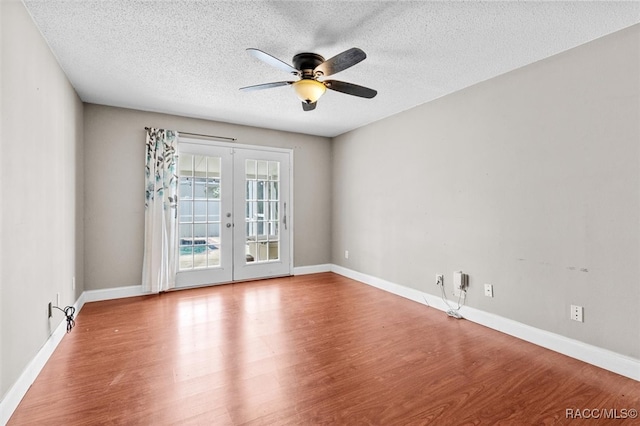 unfurnished room featuring french doors, a textured ceiling, ceiling fan, and wood-type flooring