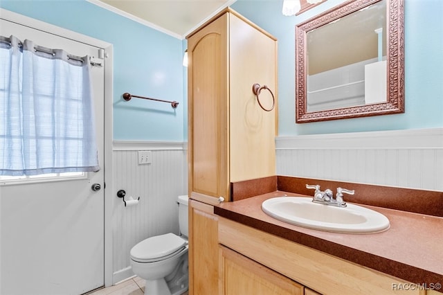 bathroom featuring tile patterned floors, vanity, toilet, and crown molding