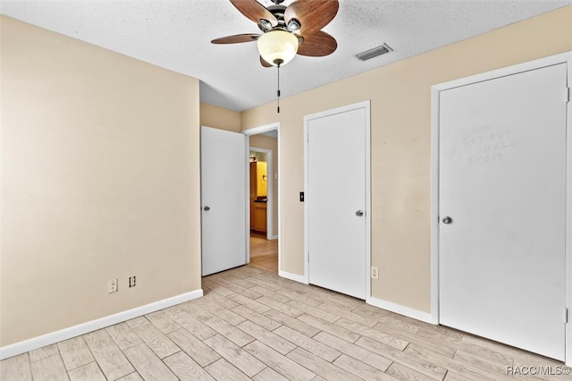 unfurnished bedroom featuring ceiling fan, a textured ceiling, and light wood-type flooring