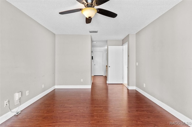 unfurnished room featuring ceiling fan, dark hardwood / wood-style flooring, and a textured ceiling