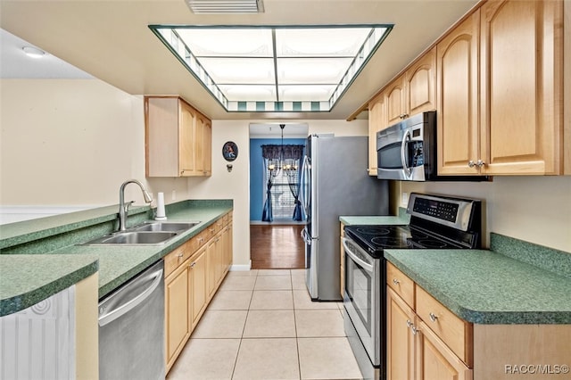 kitchen with light tile patterned flooring, light brown cabinetry, sink, and appliances with stainless steel finishes