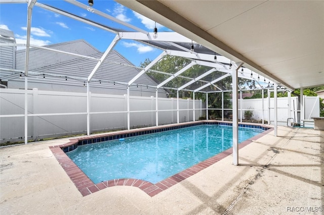 view of swimming pool with glass enclosure and a patio area