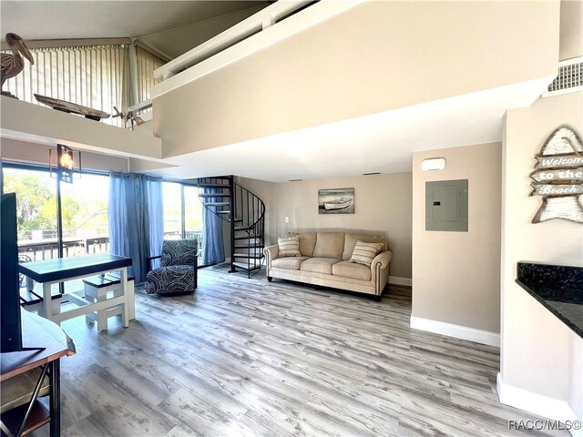 2695 N Seabreeze Pt, Crystal River, FL 34429 - living area with electric panel, stairs, wood finished floors, baseboards, and a towering ceiling