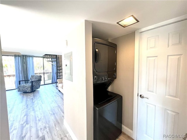 2695 N Seabreeze Pt, Crystal River, FL 34429 - laundry area featuring stacked washer / dryer, wood finished floors, electric panel, and baseboards