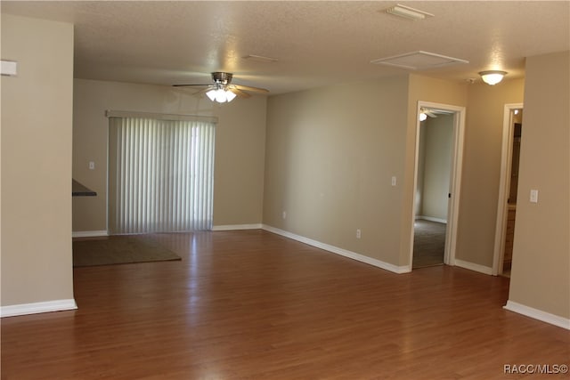 spare room featuring a textured ceiling, ceiling fan, and dark hardwood / wood-style floors