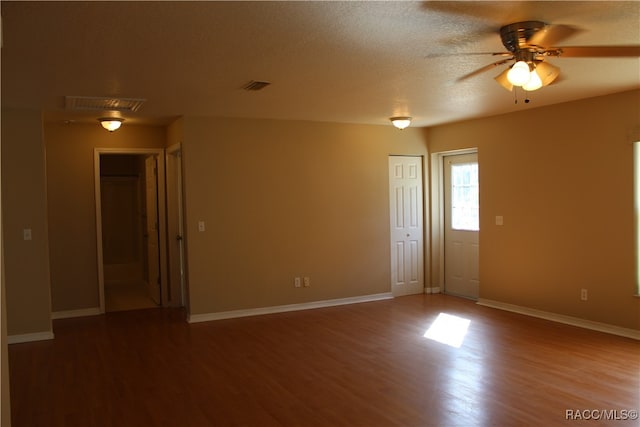 unfurnished room featuring hardwood / wood-style floors, ceiling fan, and a textured ceiling