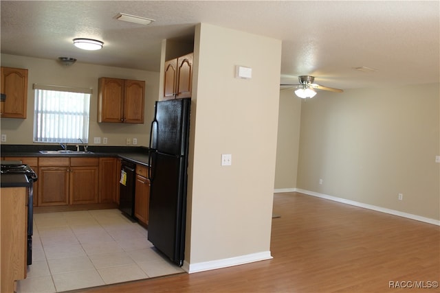 kitchen featuring a textured ceiling, light hardwood / wood-style floors, ceiling fan, and black appliances