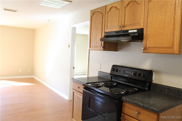 kitchen with black electric range and light hardwood / wood-style flooring