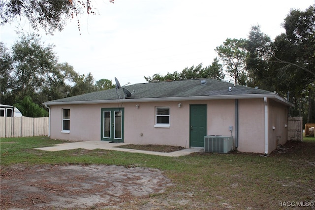 rear view of house with a yard, central AC, and a patio area