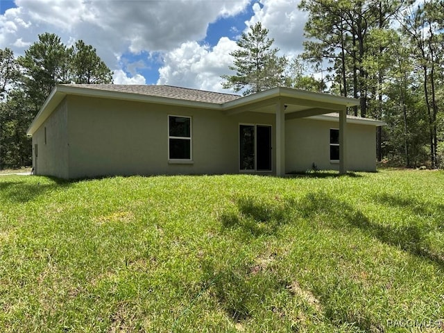 3289 W Camilo Dr, Dunnellon, FL 34433 - rear view of property featuring stucco siding and a yard