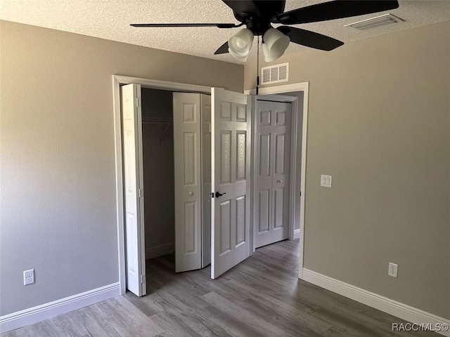 3289 W Camilo Dr, Dunnellon, FL 34433 - unfurnished bedroom with wood finished floors, a textured ceiling, a ceiling fan, and a closet