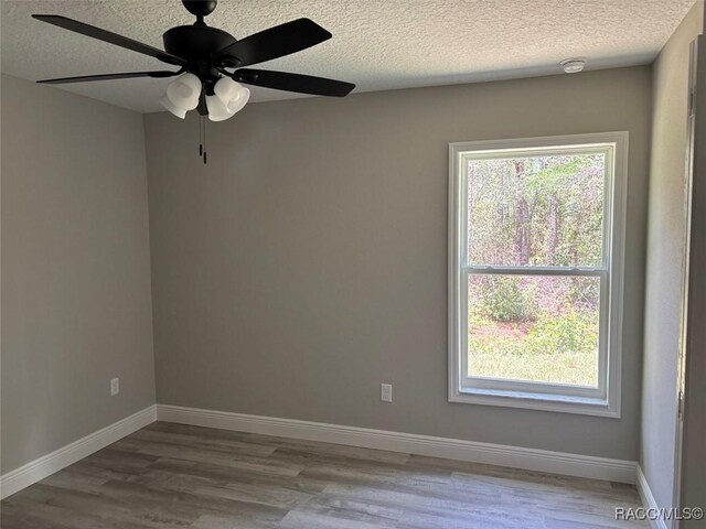 3289 W Camilo Dr, Dunnellon, FL 34433 - empty room with a smoke detector, a textured ceiling, healthy amount of natural light, and wood finished floors