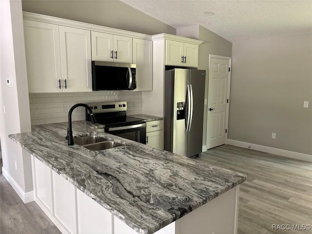 3289 W Camilo Dr, Dunnellon, FL 34433 - kitchen with appliances with stainless steel finishes, light wood finished floors, light stone countertops, tasteful backsplash, and a textured ceiling