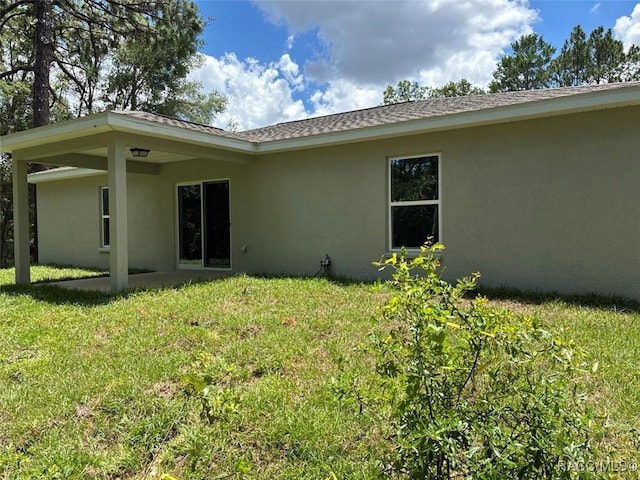 3289 W Camilo Dr, Dunnellon, FL 34433 - back of house featuring stucco siding and a lawn