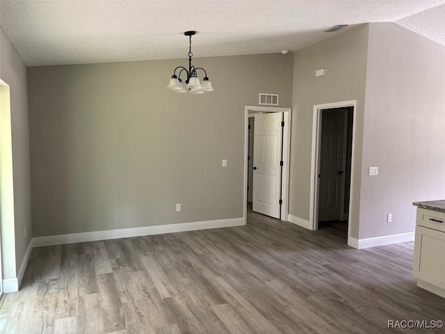 3289 W Camilo Dr, Dunnellon, FL 34433 - unfurnished dining area with a chandelier, wood finished floors, vaulted ceiling, and a textured ceiling