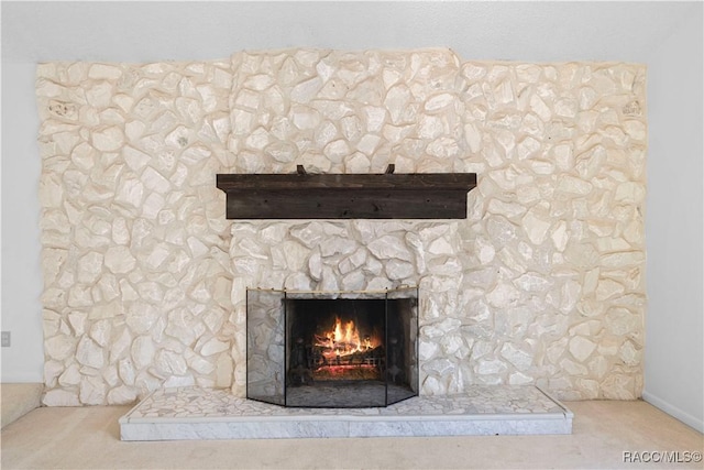 room details featuring a stone fireplace and carpet floors