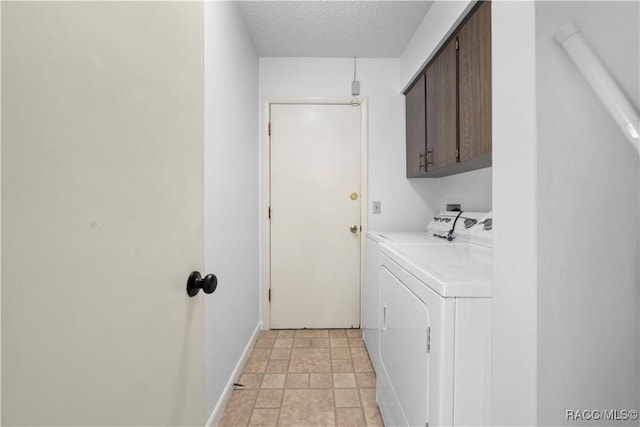 laundry area featuring washing machine and dryer, cabinets, and a textured ceiling