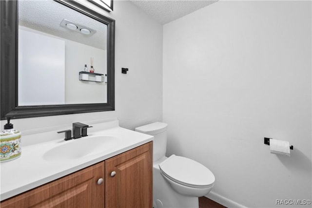 bathroom featuring vanity, toilet, and a textured ceiling