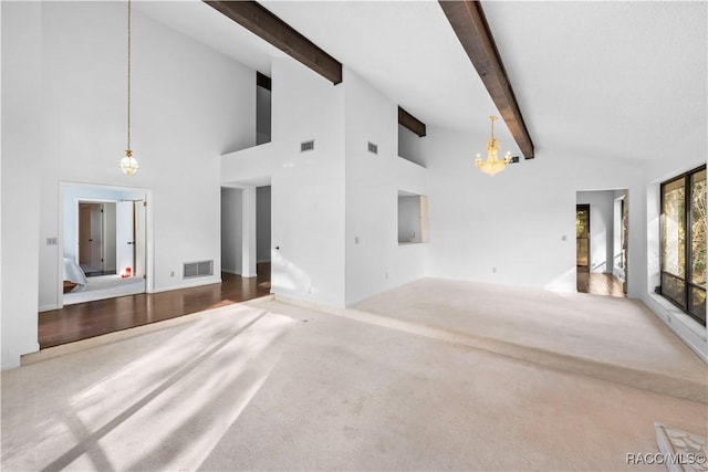 unfurnished living room with an inviting chandelier, a towering ceiling, carpet floors, and beamed ceiling