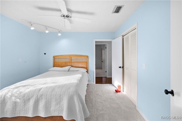 carpeted bedroom with a textured ceiling, a closet, and ceiling fan