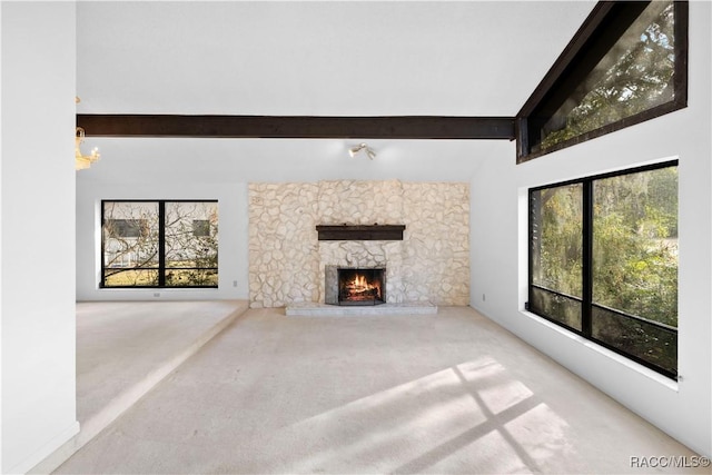 unfurnished living room featuring carpet floors, beamed ceiling, and a healthy amount of sunlight