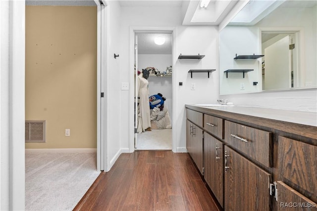 bathroom featuring hardwood / wood-style flooring, vanity, a textured ceiling, and a skylight