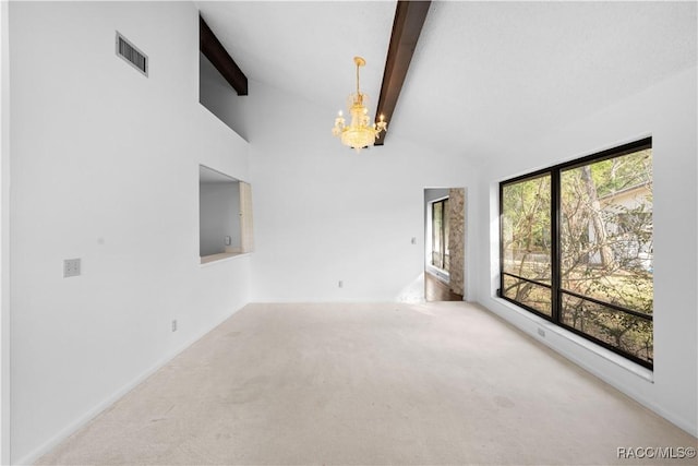 unfurnished living room with beamed ceiling, a chandelier, light carpet, and a wealth of natural light