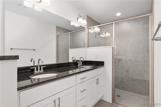 bathroom featuring vanity, hardwood / wood-style flooring, and a shower with door