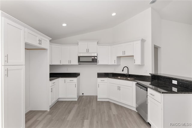 kitchen featuring white cabinetry, sink, stainless steel appliances, lofted ceiling, and light wood-type flooring