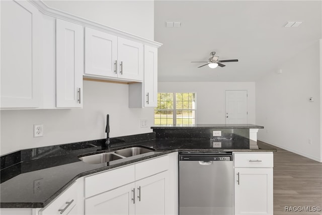 kitchen featuring white cabinetry, sink, stainless steel dishwasher, dark hardwood / wood-style floors, and dark stone countertops