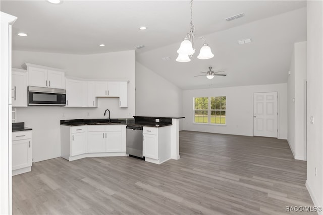 kitchen with light hardwood / wood-style flooring, sink, stainless steel appliances, and vaulted ceiling