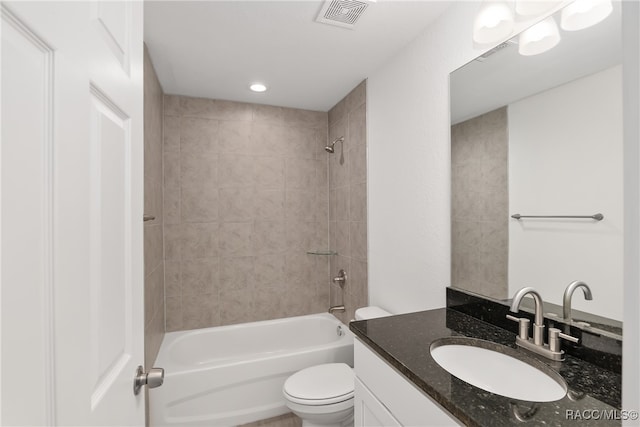 full bathroom featuring vanity, tiled shower / bath combo, and toilet