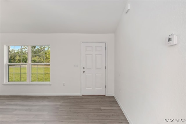 empty room featuring light wood-type flooring and lofted ceiling