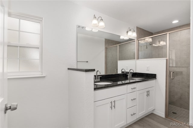 bathroom featuring wood-type flooring, vanity, and an enclosed shower