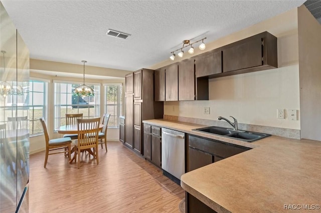 kitchen featuring dark brown cabinetry, sink, decorative light fixtures, an inviting chandelier, and dishwasher